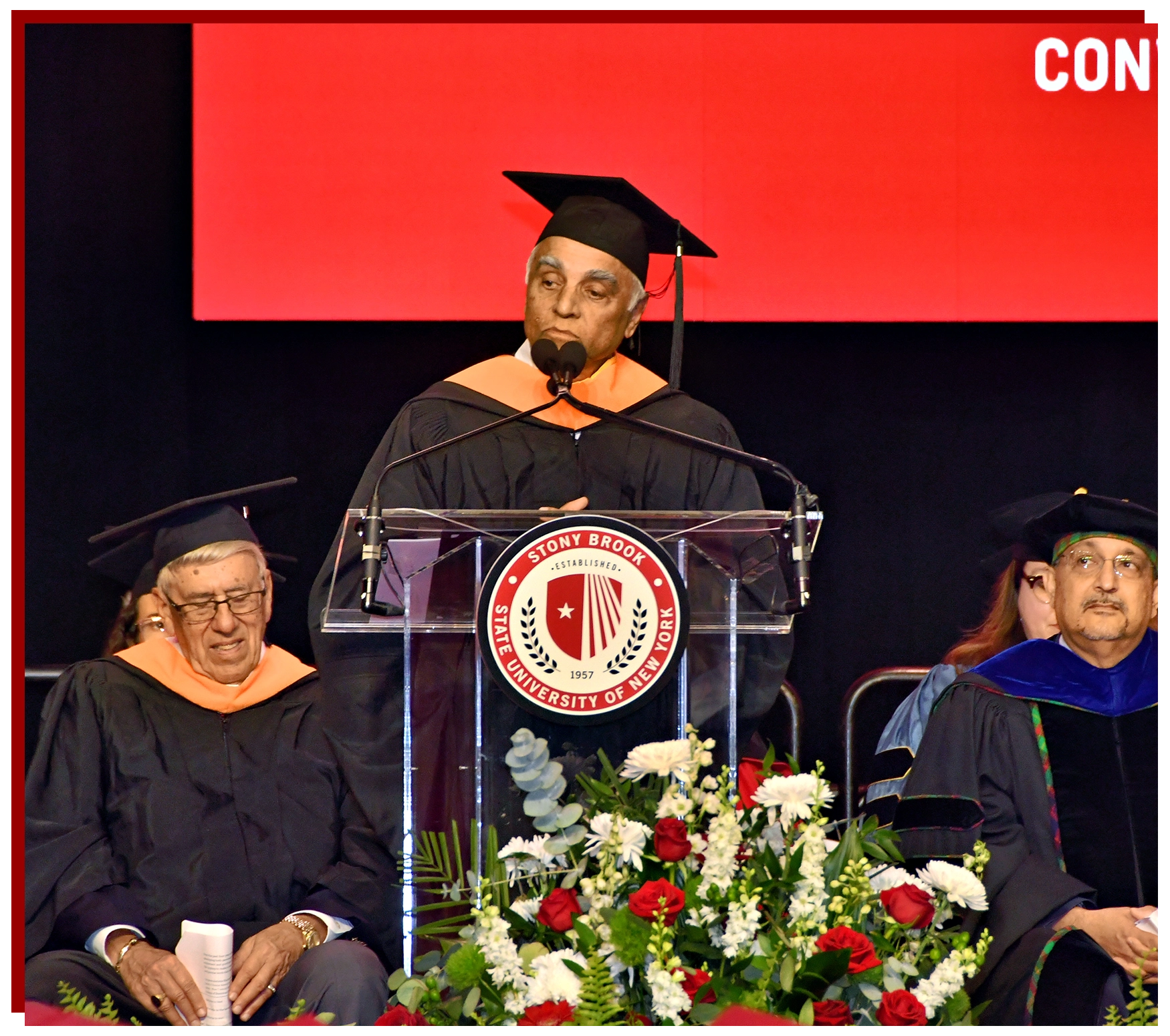 College of Business Graduate Walking Across the Stage with Diploma in hand
