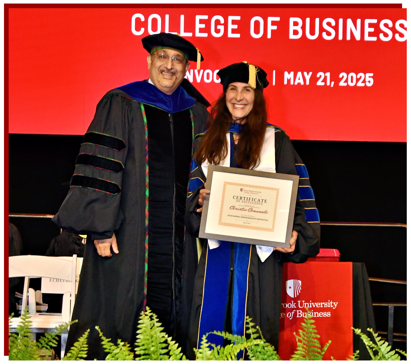 College of Business Graduate Walking Across the Stage with Diploma in hand