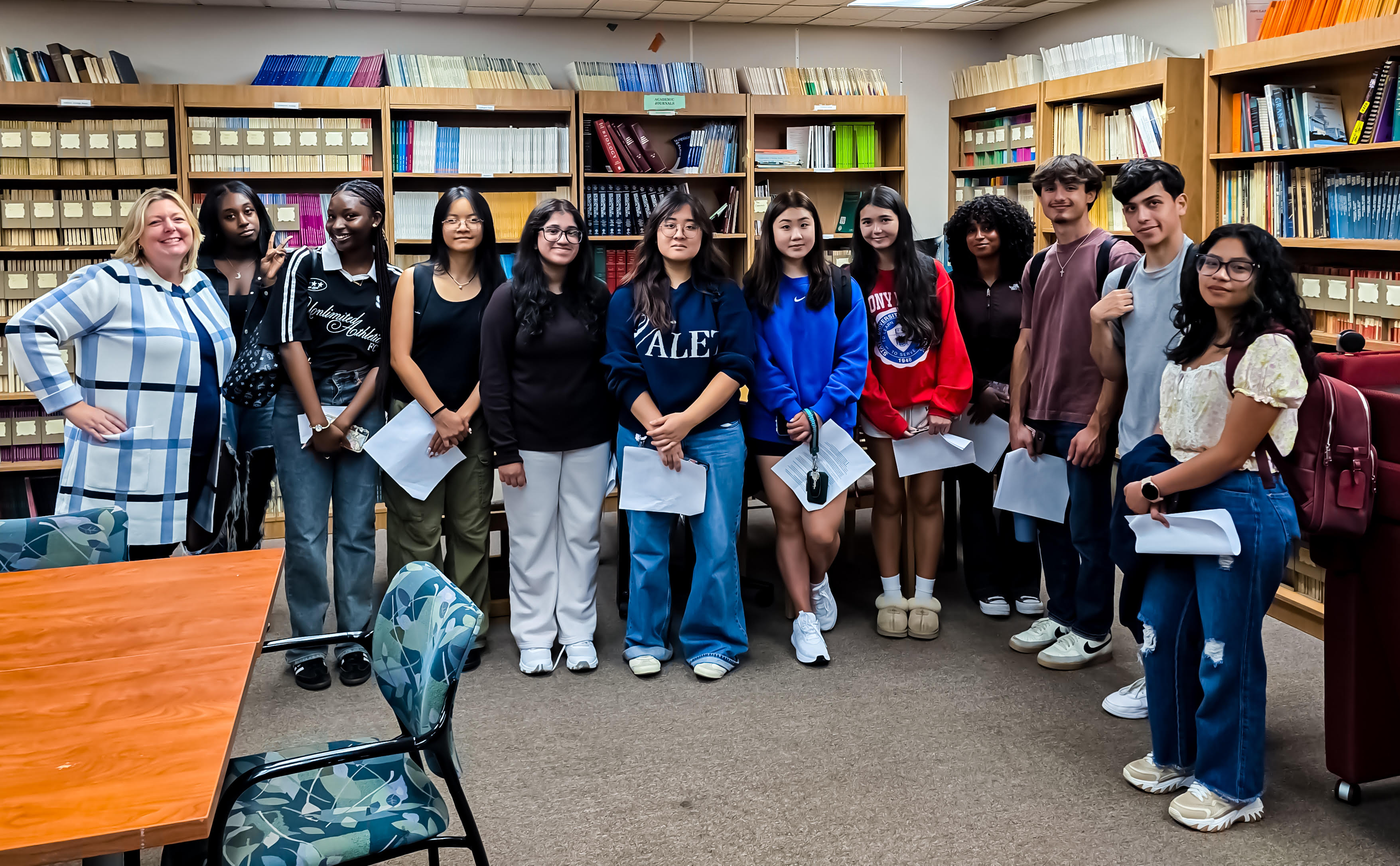 A large group of people with bookshelves in the background.